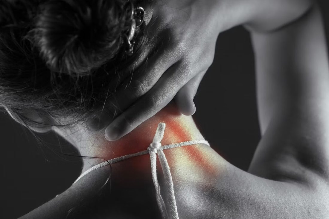 Persona che si tiene il collo con la mano per un dolore cervicale